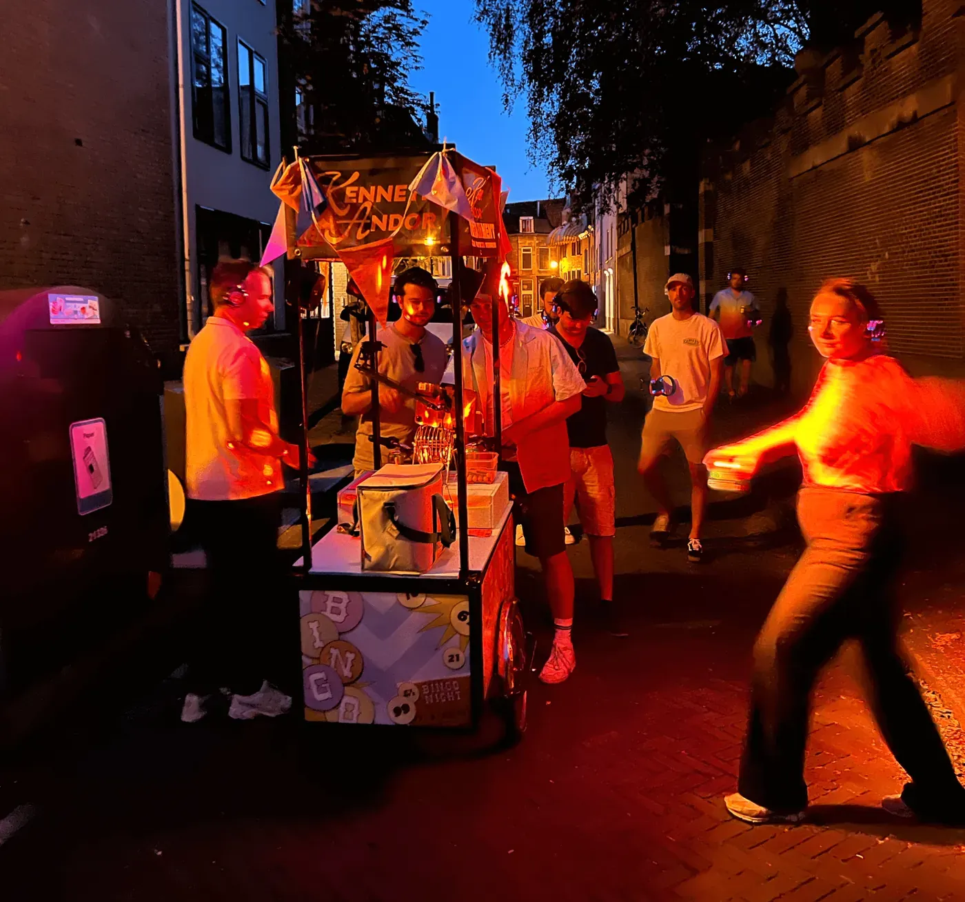 De Bingobakfiets met verlichting tijdens een avondfeest in een straat