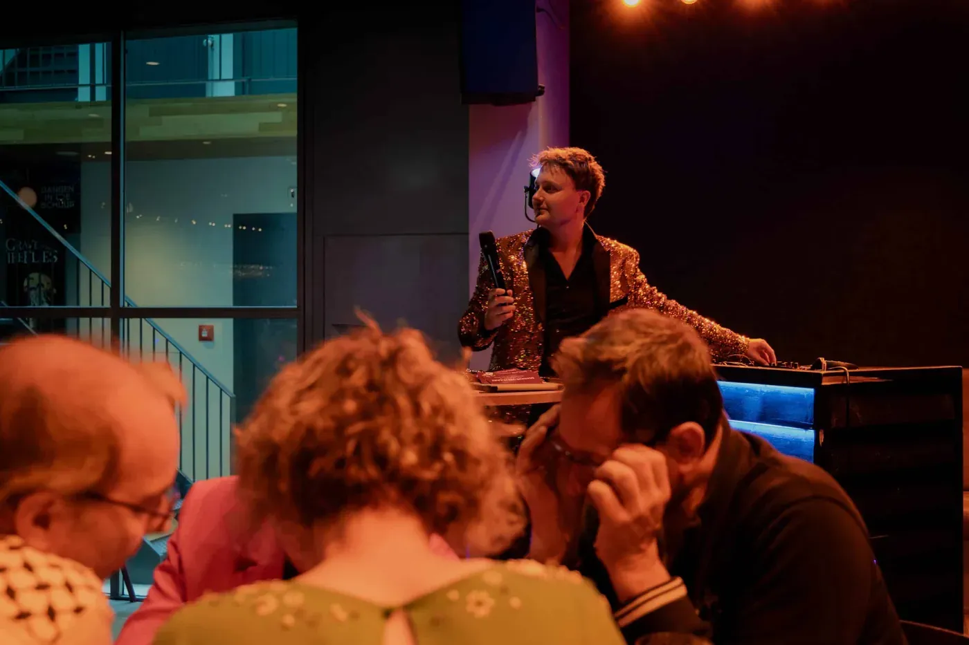 Lachende deelnemers aan een tafel tijdens de pubquiz